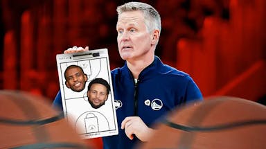 Steve Kerr holding a coaching board with Chris Paul and Stephen Curry’s face on it