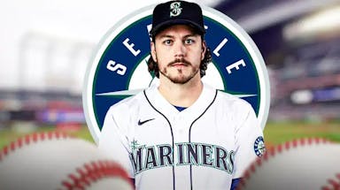 Brian Anderson wearing a Mariners jersey in front of a Mariners logo