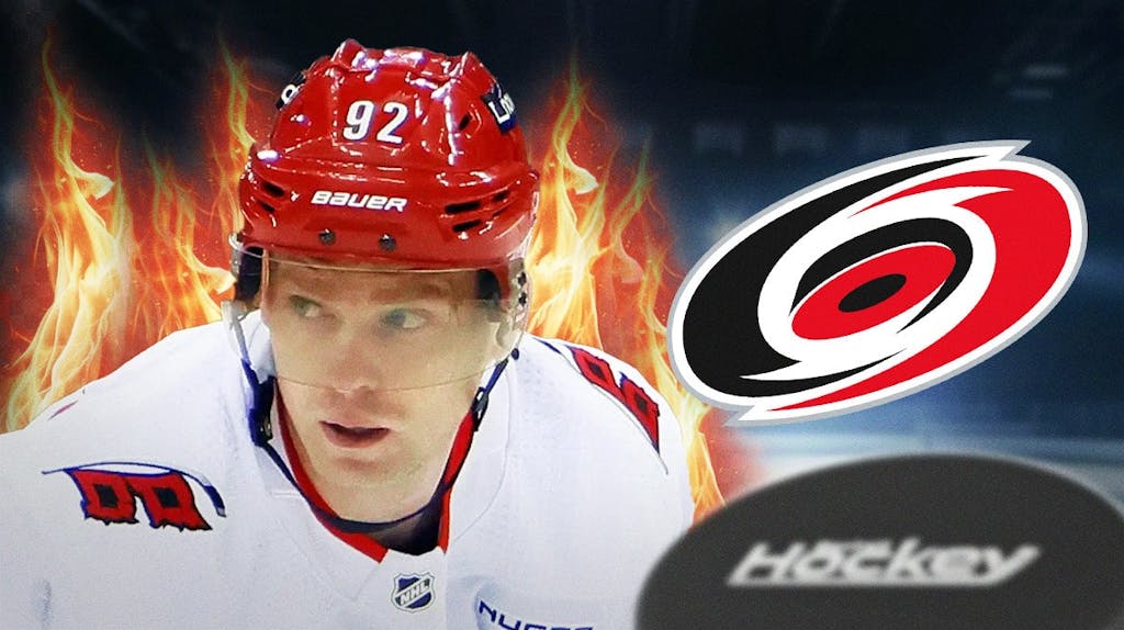 Evgeny Kuznetsov in a CAR Hurricanes jersey looking happy with fire around him, CAR Hurricanes logo, hockey rink in background