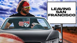 Brandon Crawford (Wearing normal clothes) driving a car on a road. Place a sign on the side of the road that reads as follows: Leaving San Francisco