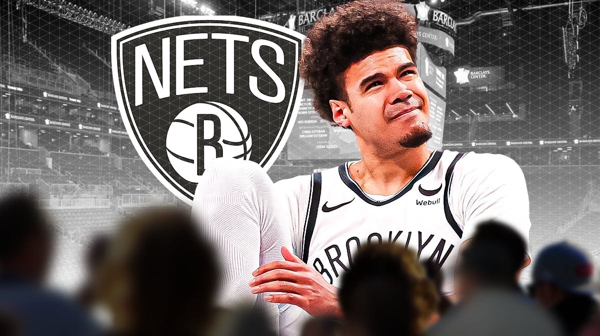 Nets Cam Johnson next to a Nets logo at Barclays Center