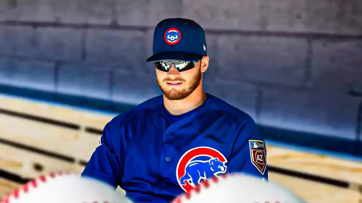 Cubs' Ian Happ sitting in an MLB dugout looking serious/upset.