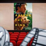 Arthur the King poster on movie theater screen.