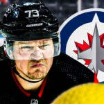 Tyler Toffoli looking stern, Winnipeg Jets logo, hockey rink in background