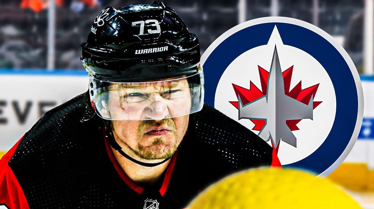 Tyler Toffoli looking stern, Winnipeg Jets logo, hockey rink in background