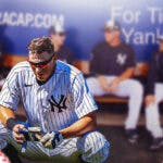 Yankees' DJ LeMahieu sitting in an MLB dugout looking upset.