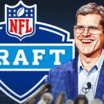 Los Angeles Chargers head coach Jim Harbaugh next to NFL Draft logo