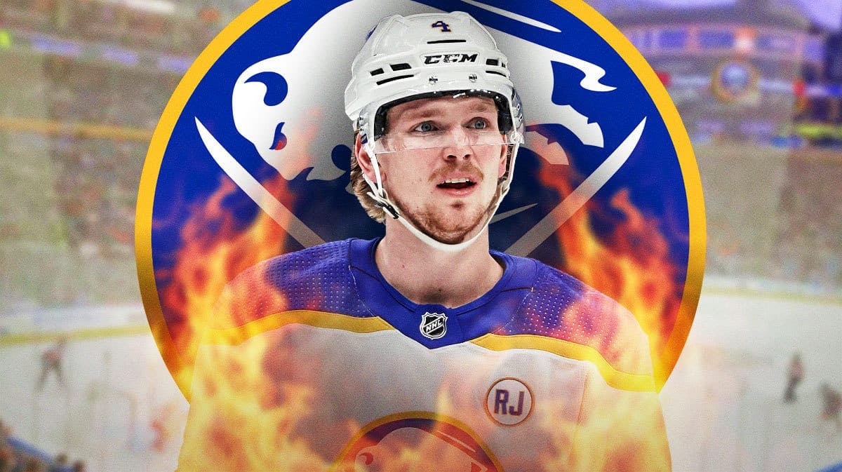 Bowen Byram in Buffalo Sabres jersey looking happy with fire around him, BUF Sabres logo, hockey rink in background