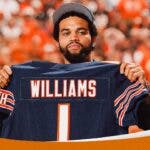 Bears' Caleb Williams holding up 2024 NFL Draft day No. 1 jersey.
