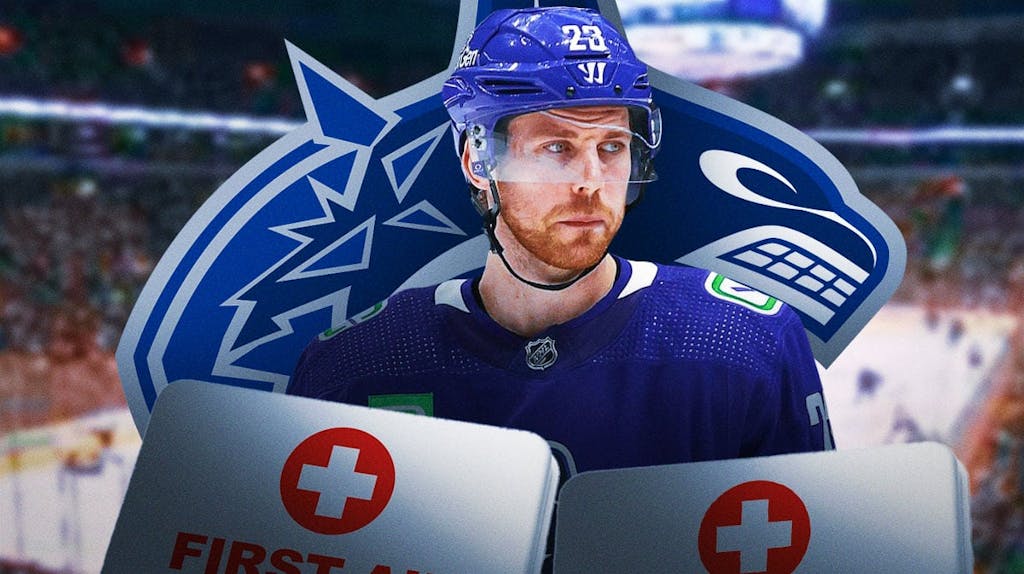 Elias Lindholm in image looking stern, first aid kit, Vancouver Canucks logo, hockey rink in background