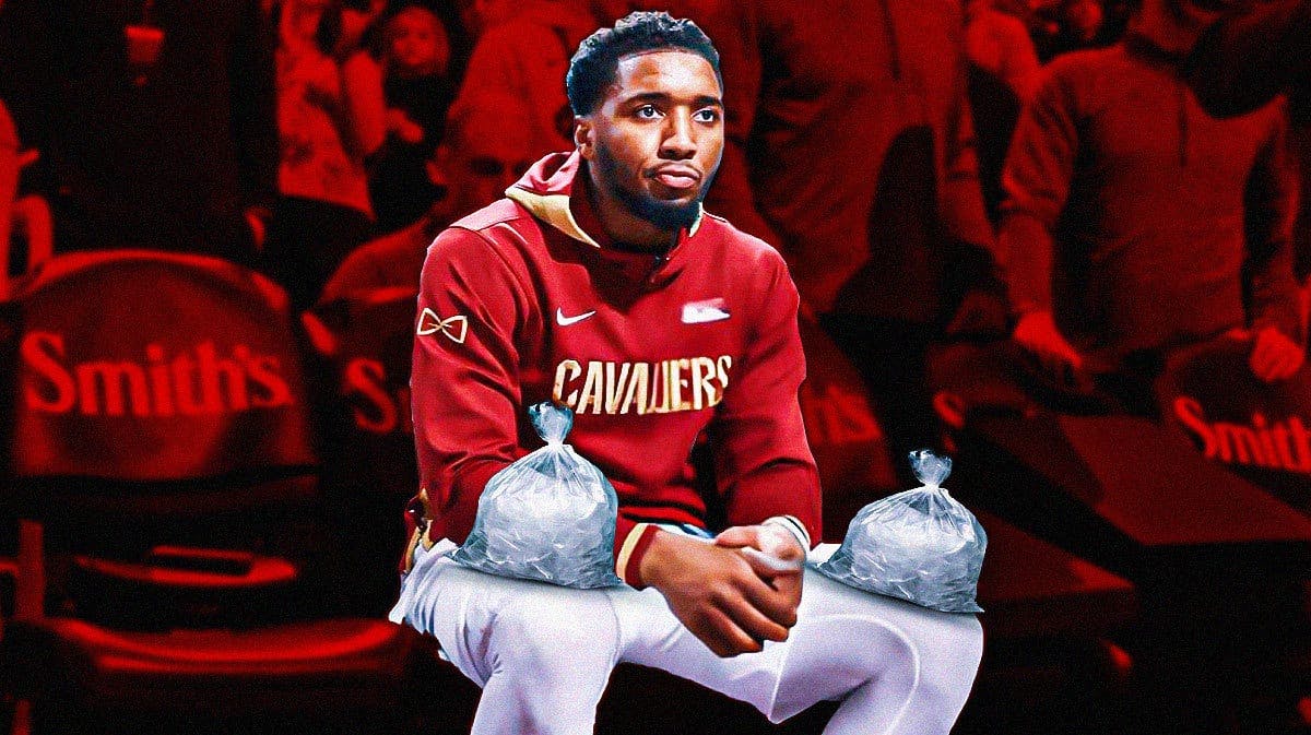 Image: Donovan Mitchell sitting on bench with ice on his knees with Cavs colors/logo and a basketball court in the background
