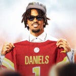 Ex-LSU football QB Jayden Daniels stands with Commanders jersey at NFL Draft, promise note hangs in background