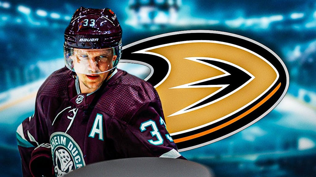 Jakob Silfverberg in middle of image looking happy, Anaheim Ducks logo, hockey rink in background