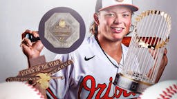Orioles' Jackson Holliday smiling, with MVP, Rookie of the Year, and World Series trophies falling from the sky all over him