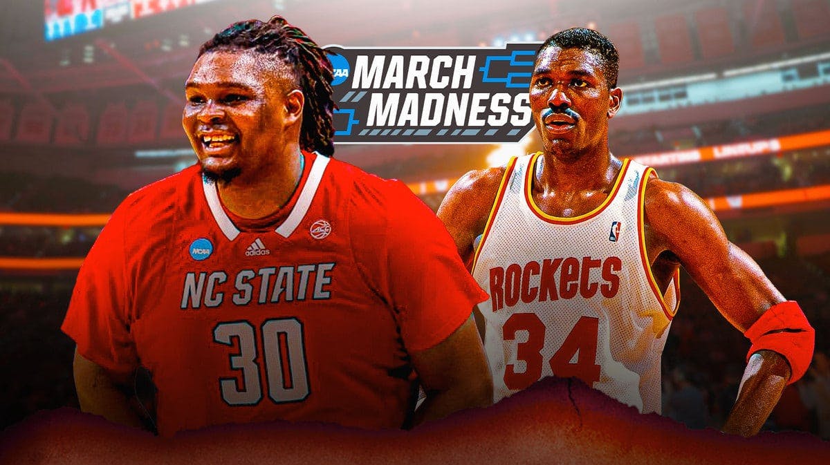 NC State basketball's DJ Burns stands next to Hakeem Olajuwon and March Madness logo, Final Four fans in background